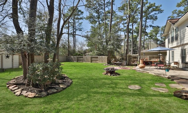 view of yard featuring an outdoor fire pit, a fenced backyard, and a patio area