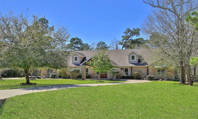 cape cod home featuring stone siding, concrete driveway, and a front lawn