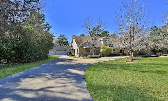 view of front facade with a garage, a front yard, and an outdoor structure