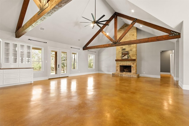 unfurnished living room featuring concrete floors, a fireplace, visible vents, baseboards, and beamed ceiling