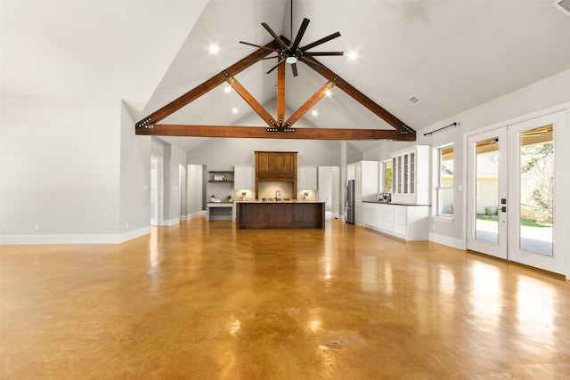 unfurnished living room featuring high vaulted ceiling, a sink, baseboards, french doors, and finished concrete floors