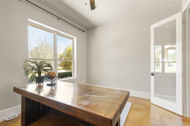 office area with a ceiling fan, visible vents, finished concrete flooring, and baseboards