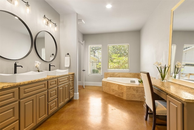 bathroom with finished concrete flooring, double vanity, a sink, baseboards, and a bath