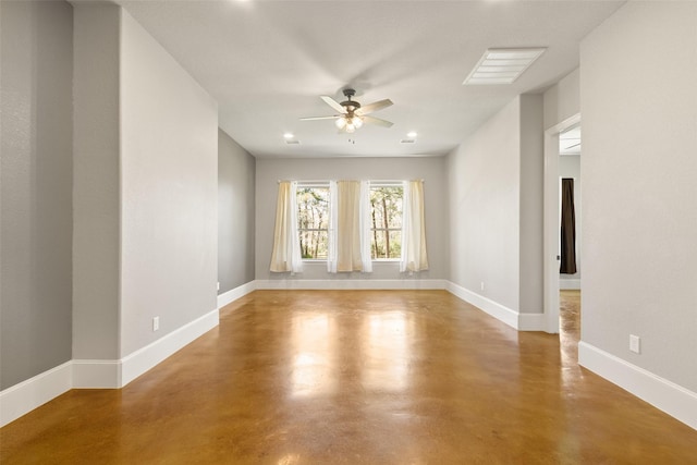 spare room with ceiling fan, concrete floors, and baseboards