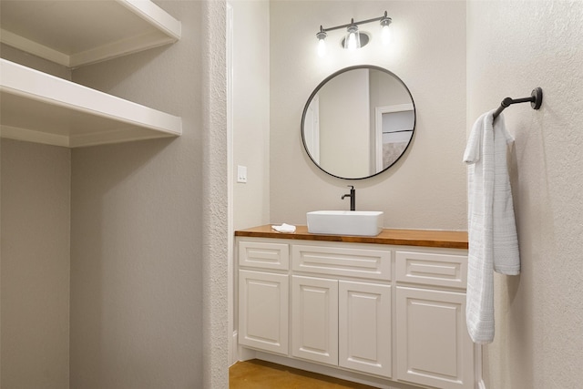 bathroom featuring a textured wall and vanity