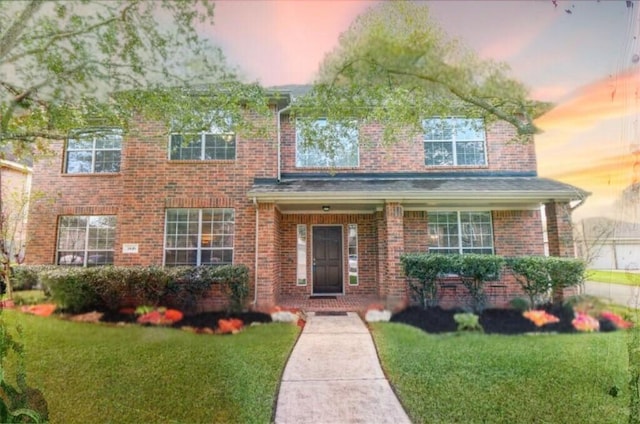 view of front of house featuring brick siding and a front lawn