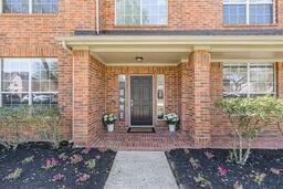 view of exterior entry featuring brick siding