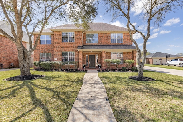 view of front of home featuring brick siding and a front yard