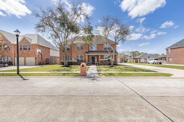 view of front of house with brick siding, a front lawn, concrete driveway, and a garage