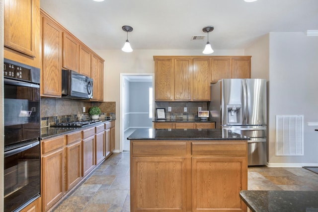 kitchen with visible vents, black appliances, a center island, and stone finish floor