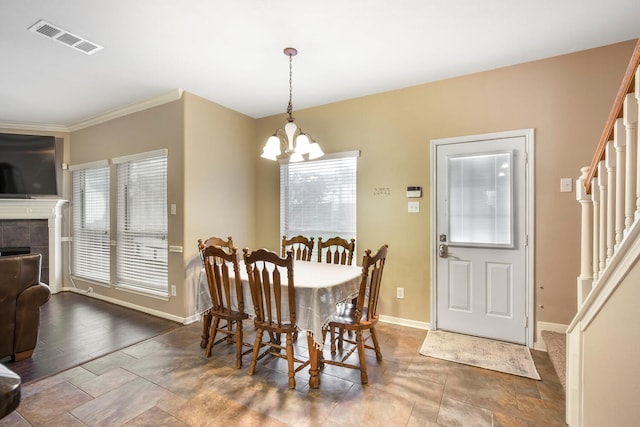 dining space with visible vents, baseboards, a chandelier, stairway, and a fireplace