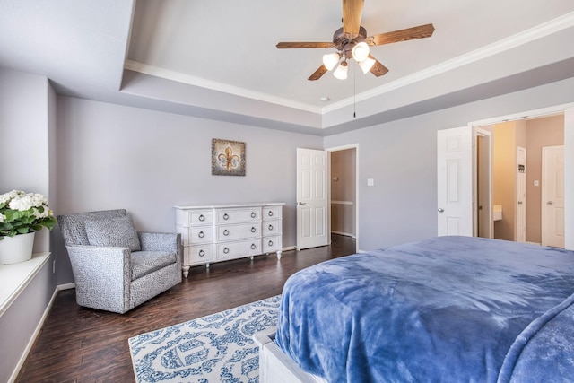 bedroom featuring wood finished floors, baseboards, a tray ceiling, ceiling fan, and crown molding