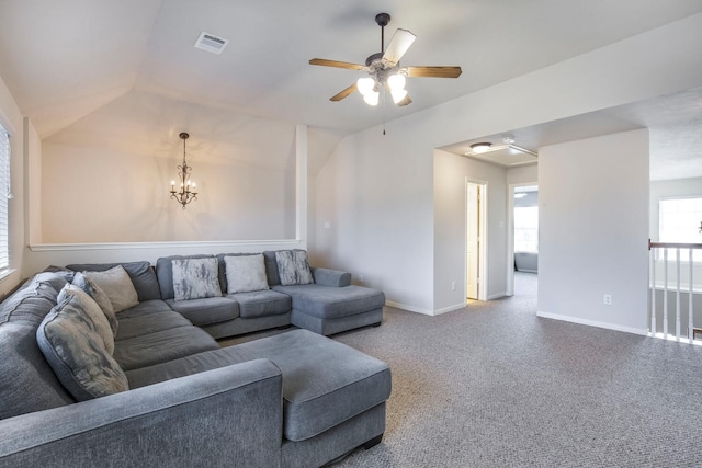 carpeted living room featuring visible vents, baseboards, vaulted ceiling, and ceiling fan with notable chandelier