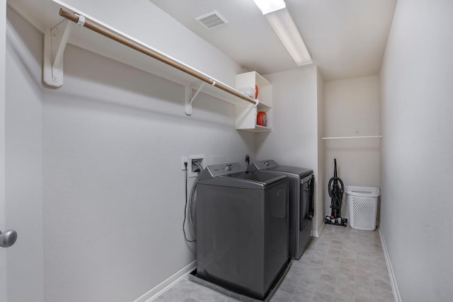 laundry area featuring visible vents, baseboards, light floors, laundry area, and separate washer and dryer