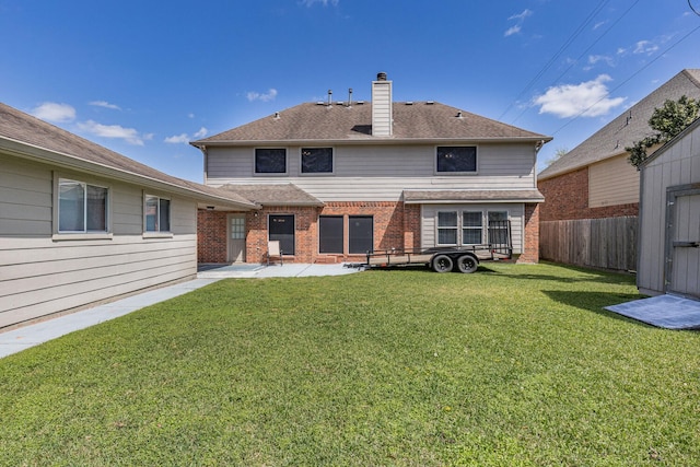 rear view of house featuring brick siding, fence, roof with shingles, a chimney, and a yard