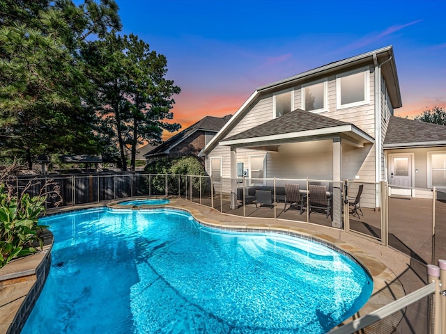 view of swimming pool with a fenced in pool, a patio, outdoor dining space, fence, and an in ground hot tub