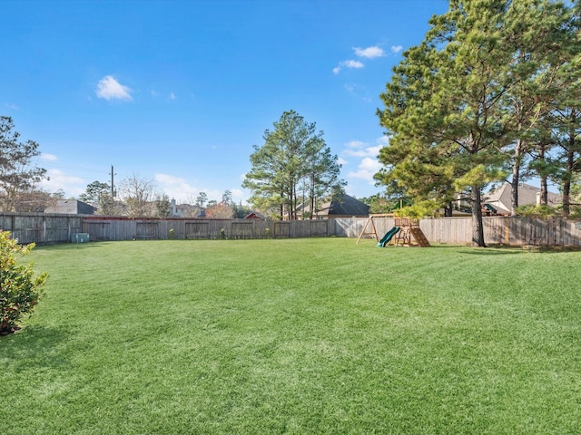 view of yard featuring a playground and a fenced backyard