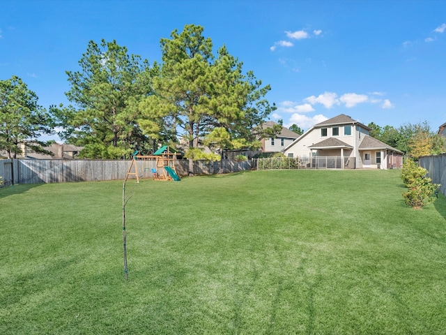 view of yard featuring a playground and a fenced backyard