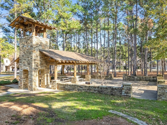 view of property's community featuring a patio and a lawn