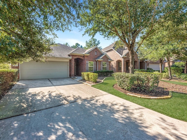 view of front of home featuring brick siding, roof with shingles, concrete driveway, an attached garage, and a front lawn