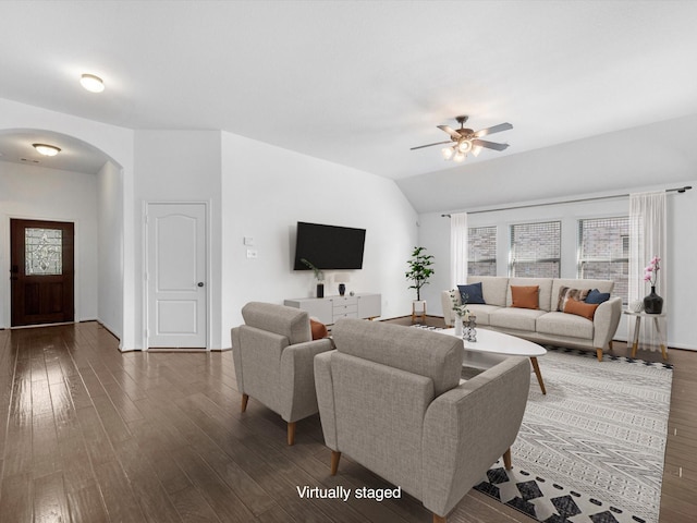 living area with a ceiling fan, arched walkways, vaulted ceiling, and wood finished floors