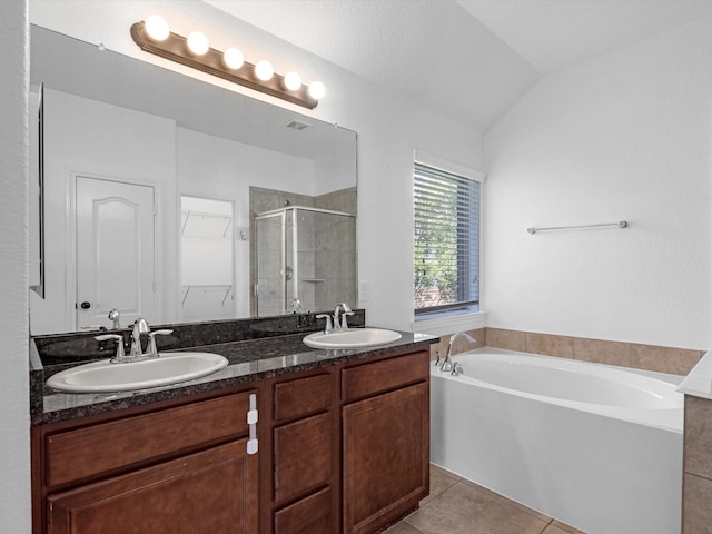 bathroom with double vanity, a stall shower, tile patterned flooring, and a sink