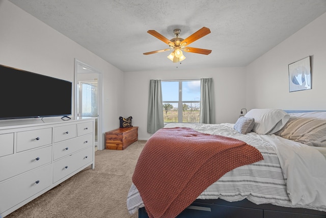 bedroom with light colored carpet, ceiling fan, and a textured ceiling