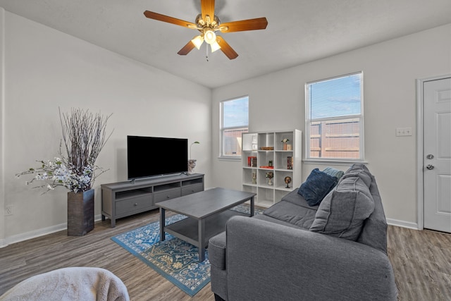 living room with a ceiling fan, baseboards, and wood finished floors