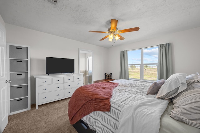 carpeted bedroom with a ceiling fan and a textured ceiling