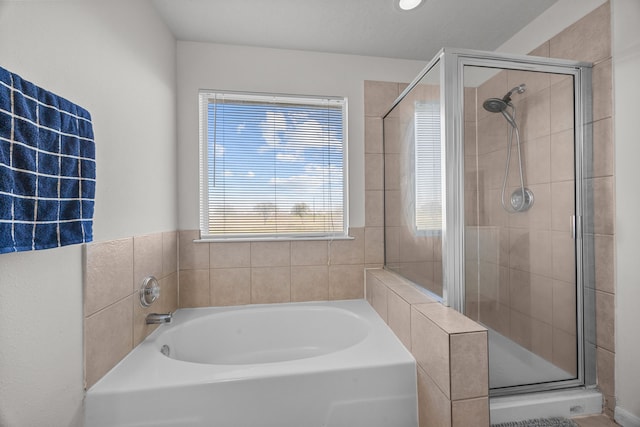 full bathroom with a stall shower and a bath