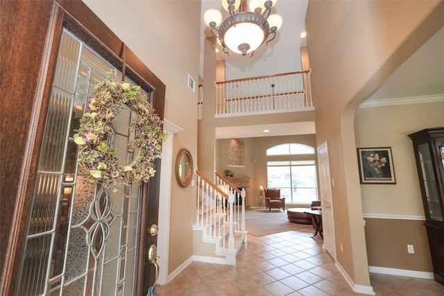 tiled foyer entrance featuring stairs, a towering ceiling, visible vents, and baseboards