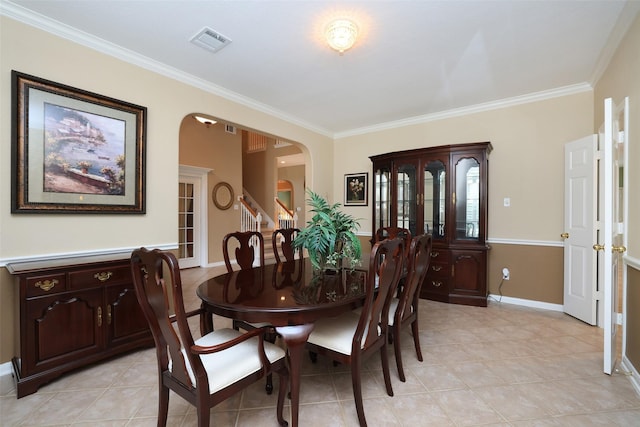 dining area with baseboards, visible vents, arched walkways, ornamental molding, and stairs