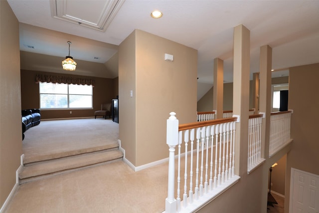 hallway featuring carpet floors, visible vents, attic access, an upstairs landing, and baseboards