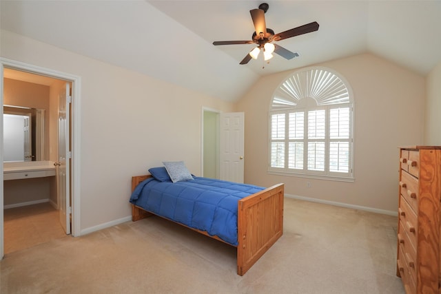 bedroom featuring light carpet, ensuite bath, baseboards, and lofted ceiling