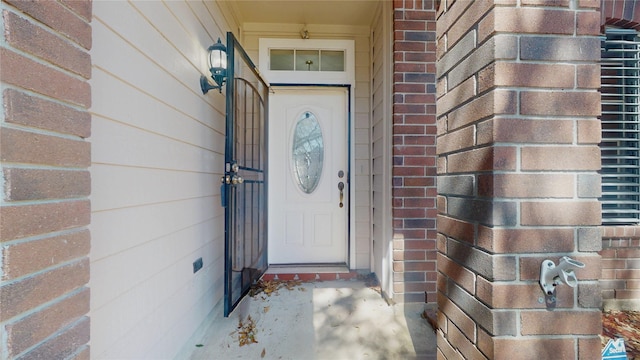 doorway to property with brick siding