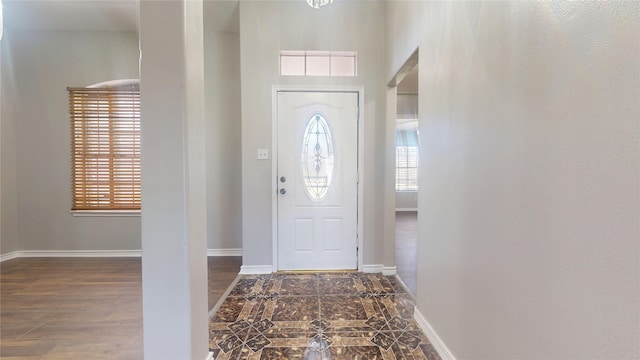 foyer entrance with baseboards and wood finished floors