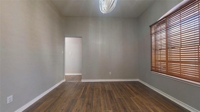 empty room featuring baseboards and dark wood-style flooring