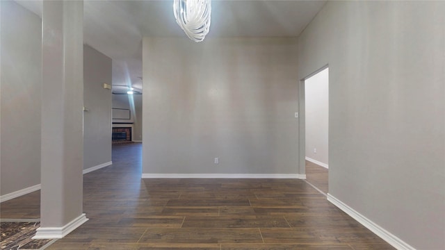 interior space featuring baseboards, a fireplace, and dark wood-style flooring