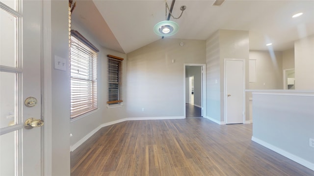 unfurnished room with vaulted ceiling, baseboards, and dark wood-style flooring