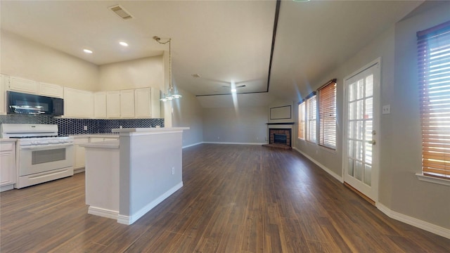 kitchen featuring white range with gas cooktop, tasteful backsplash, a glass covered fireplace, black microwave, and light countertops