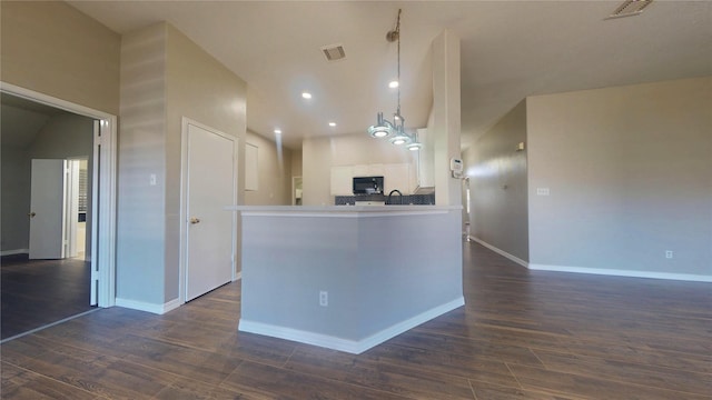 kitchen with visible vents, pendant lighting, dark wood-style floors, white cabinetry, and black microwave