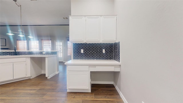 unfurnished office featuring dark wood-type flooring, visible vents, baseboards, and a sink