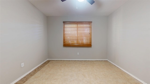 empty room featuring ceiling fan and baseboards