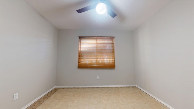 unfurnished room with a ceiling fan and baseboards