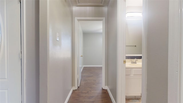 hallway with dark wood finished floors and baseboards