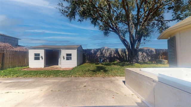 view of yard featuring a patio area, an outbuilding, a fenced backyard, and a shed