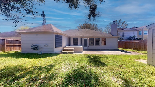 back of property with a patio, a lawn, and fence