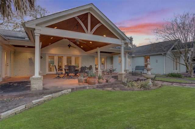 back of house with a ceiling fan, a yard, a patio area, and brick siding