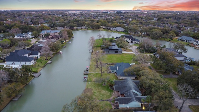 aerial view at dusk with a residential view and a water view