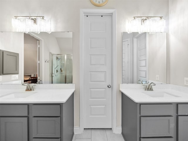 bathroom with a stall shower, two vanities, and a sink